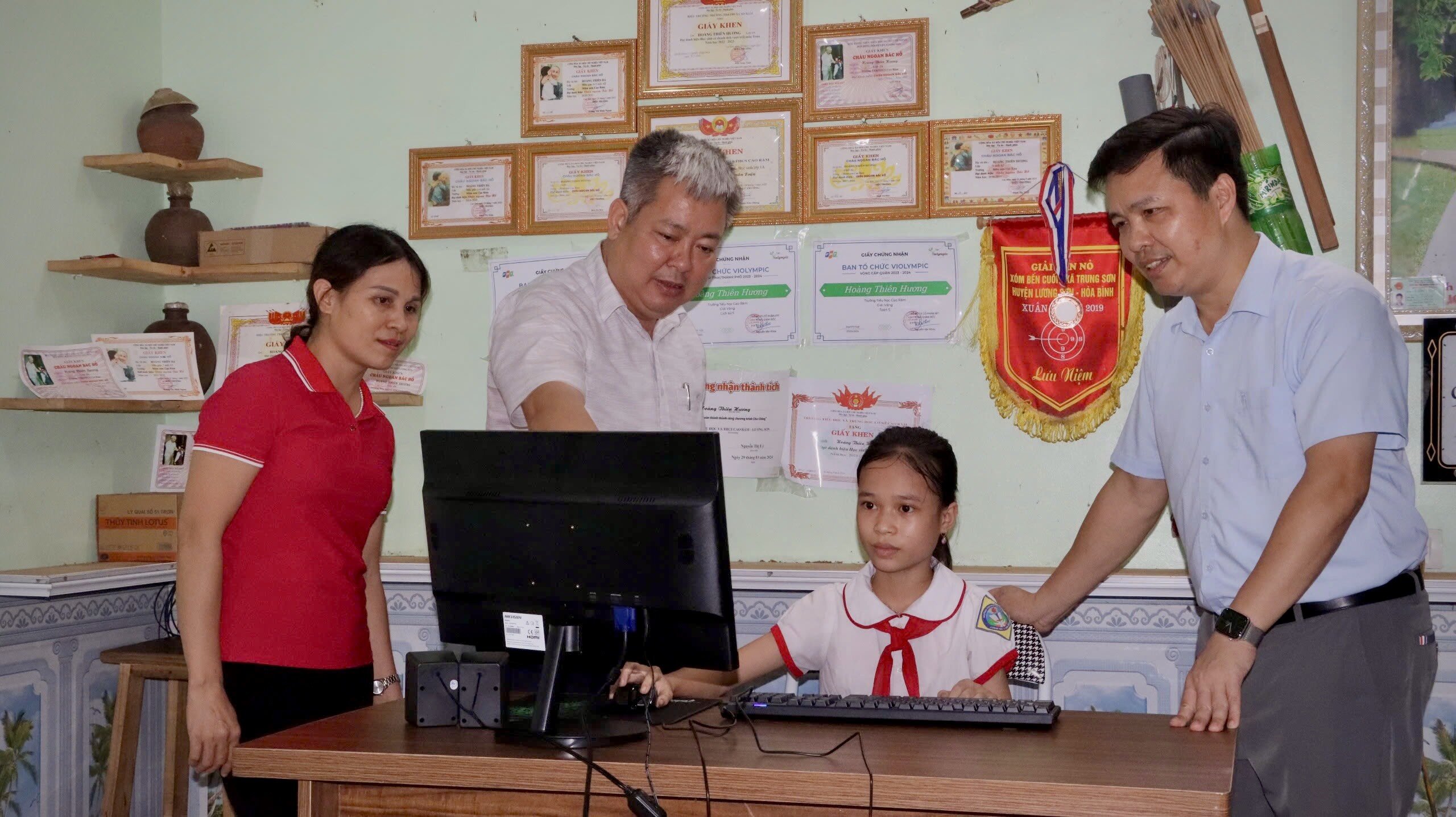 Ảnh: Lãnh đạo huyện Lương Sơn thăm và tặng bộ máy vi tính cho em Hoàng Thiên Hương